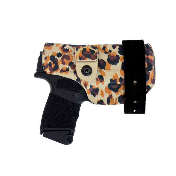 Handgun with leopard print holster on a white background
