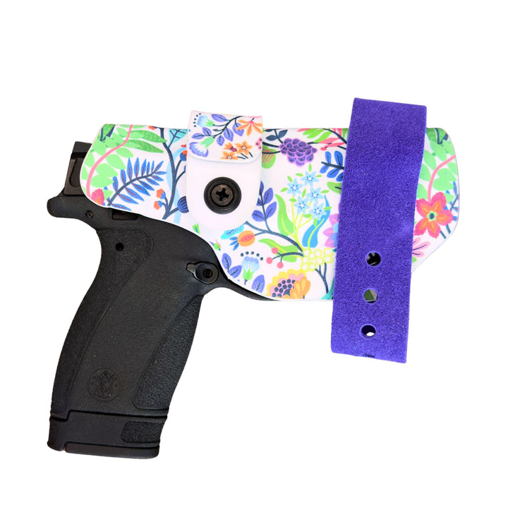 Black gun with a colorful floral holster on a white background