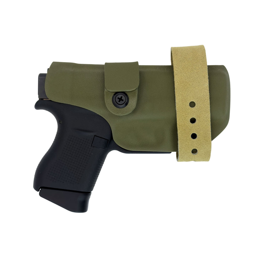 Black handgun with an olive green holster and tan belt strap on a white background