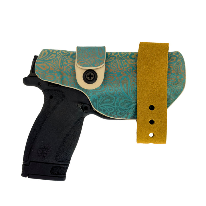 Black handgun with a green and gold patterned holster on a white background