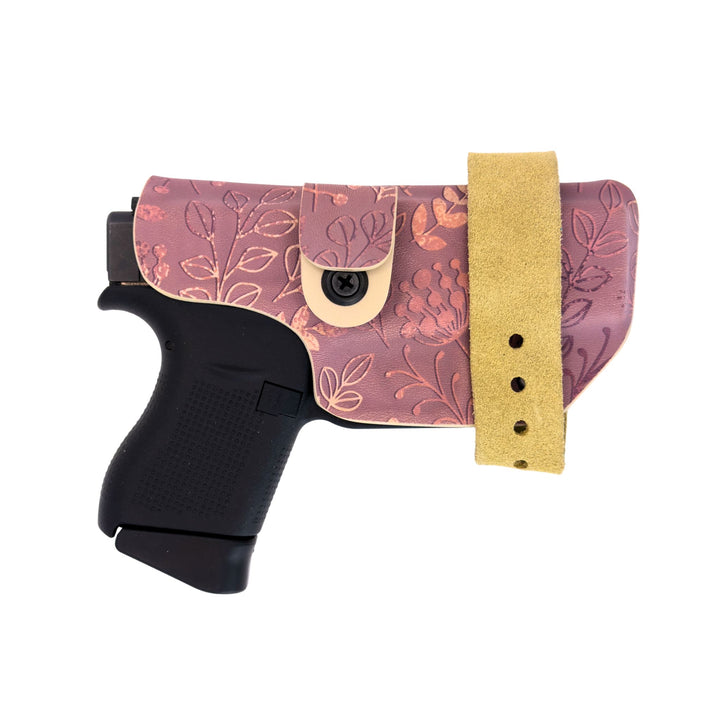 Floral-patterned gun holster with a tan strap on a white background